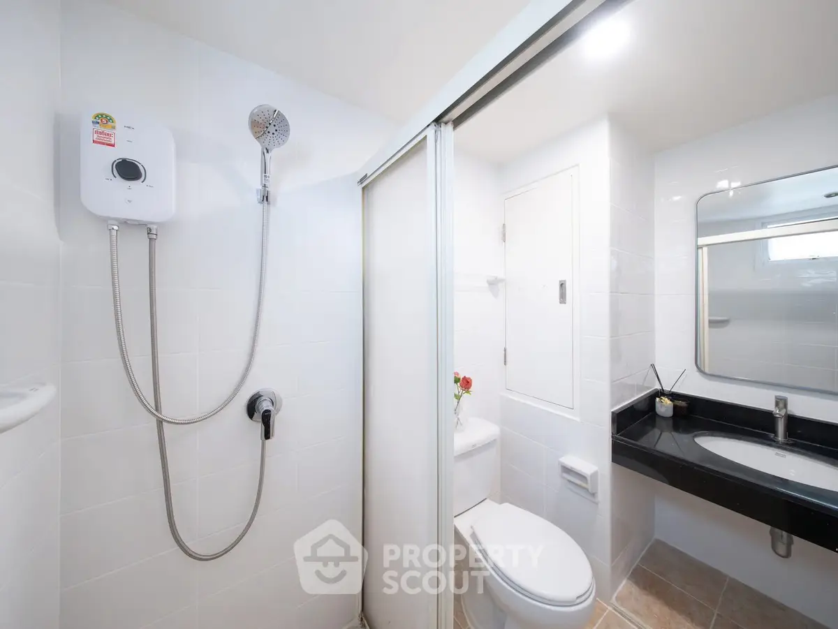 Modern bathroom with sleek shower and elegant vanity in a contemporary apartment.