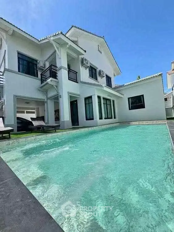 Luxurious modern villa with private pool and elegant architecture under clear blue skies.