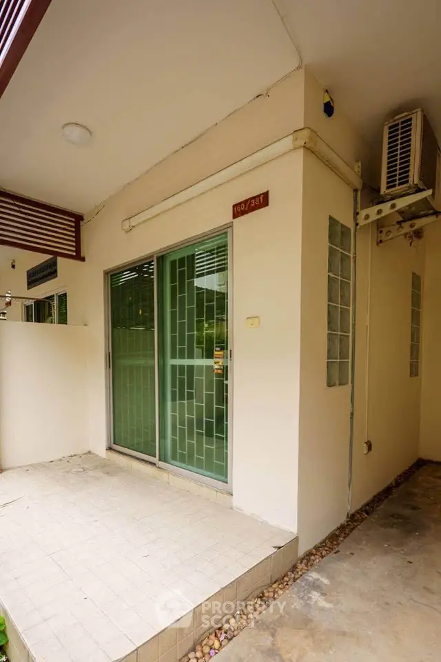 Charming exterior entrance with sliding glass doors and air conditioning unit.