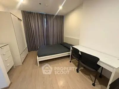 Modern minimalist bedroom with study desk and ample storage space.