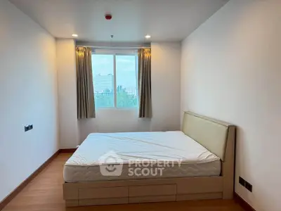 Spacious bedroom with large window offering a scenic view, featuring a comfortable bed and minimalist decor.