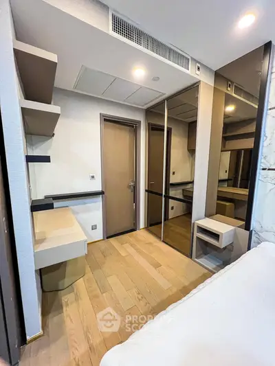 Modern bedroom with wooden flooring and mirrored closet doors