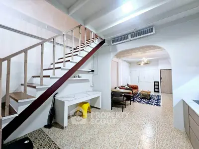 Charming open-layout living room with staircase and modern decor