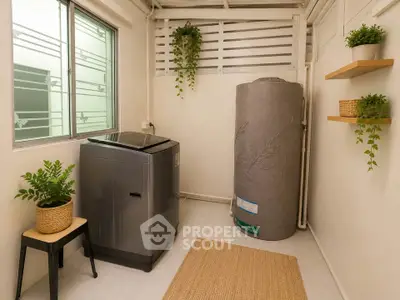 Charming laundry area with washing machine and water heater, featuring modern decor and natural light.