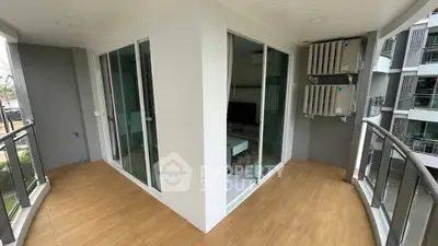 Modern corner balcony with sliding glass doors and air conditioning units.