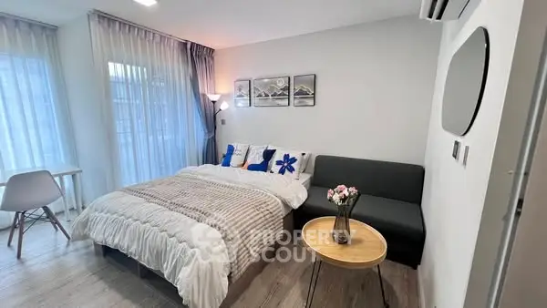 Modern bedroom with cozy bed, stylish decor, and natural light.