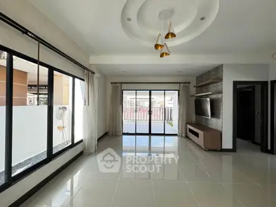 Spacious modern living room with large windows and stylish ceiling lights