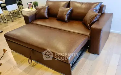 Stylish brown leather sofa bed in modern living room setting.