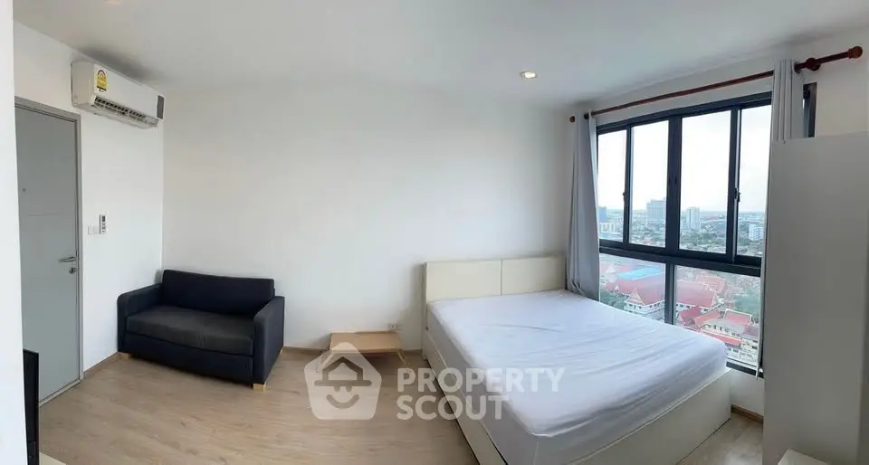 Bright and airy bedroom with city view, featuring modern furnishings and large windows.