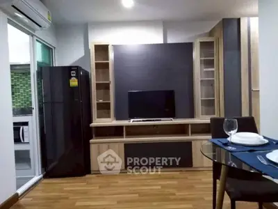 Modern living room with wooden flooring, TV unit, and dining area in a stylish apartment.