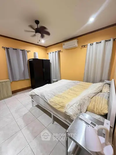 Cozy bedroom with modern furnishings and air conditioning, perfect for relaxation.