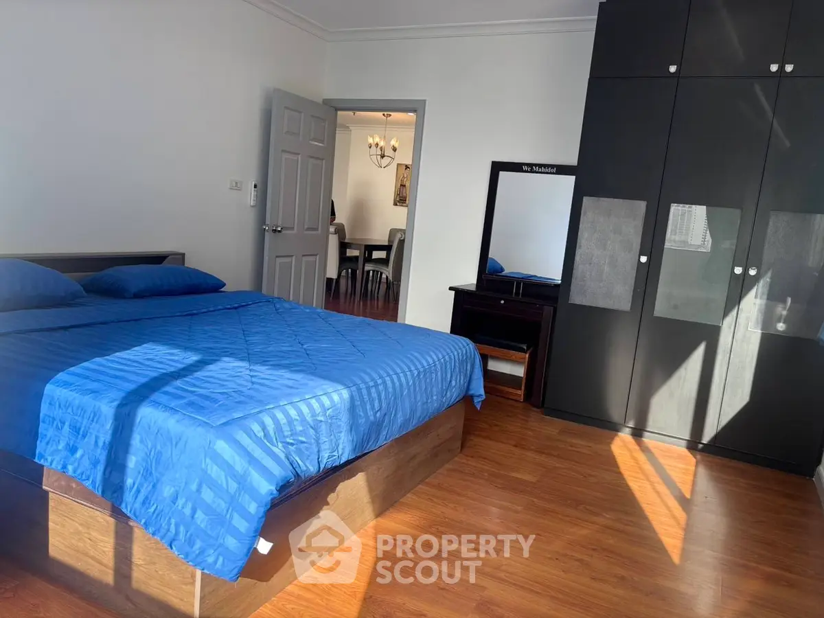 Spacious bedroom with blue bedding and ample natural light