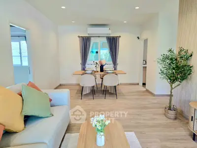 Modern living room with stylish decor and dining area, featuring cozy seating and elegant table setting.
