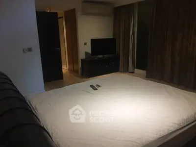 Spacious bedroom with modern decor and large bed, perfect for relaxation.