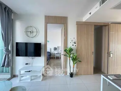 Modern living room with sleek TV setup and stylish decor in a contemporary apartment.