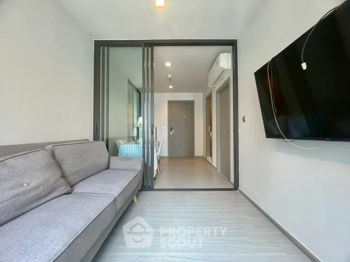 Modern living room with sleek design and wall-mounted TV in a stylish apartment.