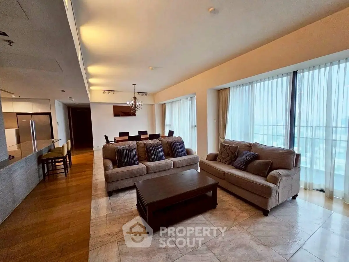 Spacious modern living room with elegant decor and large windows offering natural light