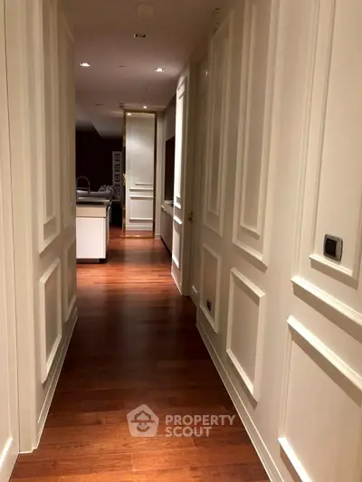 Elegant hallway with wooden flooring leading to a modern kitchen
