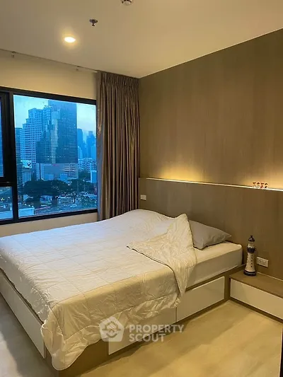 Modern bedroom with city view, featuring elegant lighting and stylish decor, perfect for urban living.
