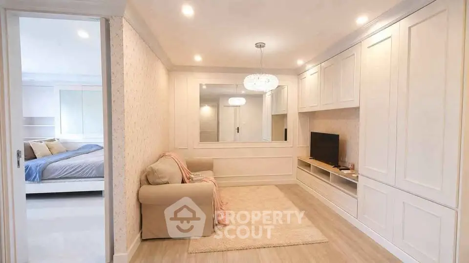 Charming living room with cozy sofa and elegant built-in cabinetry, adjacent to a serene bedroom retreat.