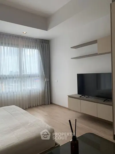 Modern bedroom with large window, sleek TV setup, and minimalist decor