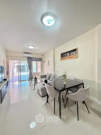 Spacious modern living room with elegant dining area and large windows for natural light.