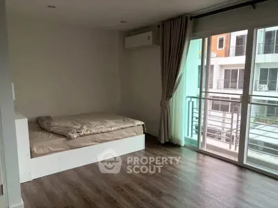Spacious bedroom with large window and balcony access in modern apartment