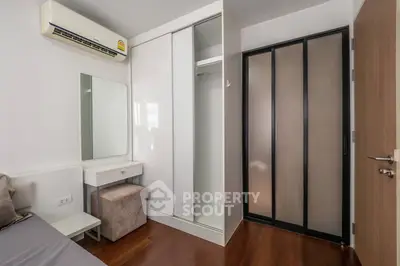Modern bedroom with sleek closet and air conditioning unit, featuring a minimalist design.