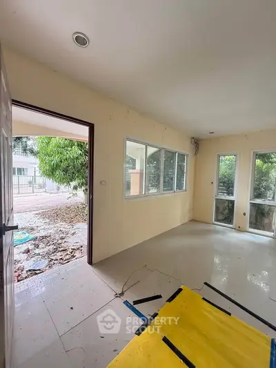 Spacious room with large windows and outdoor view, ideal for natural light lovers.