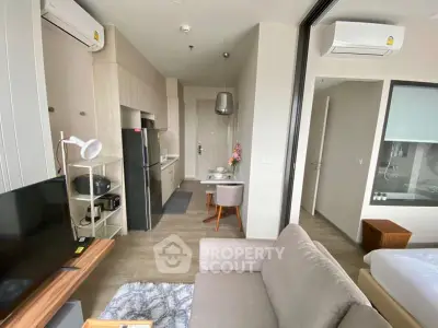 Modern studio apartment with open layout, featuring cozy living area and compact kitchen.
