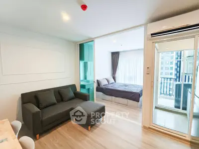 Modern apartment with open living room and bedroom, featuring a balcony view.