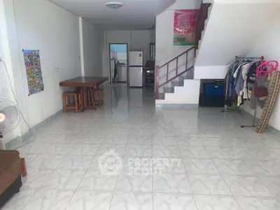 Spacious open-plan living area with tiled flooring and staircase, ideal for family gatherings.