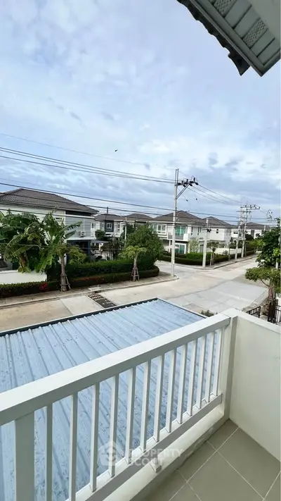 Charming suburban view from a cozy balcony overlooking a quiet residential street.