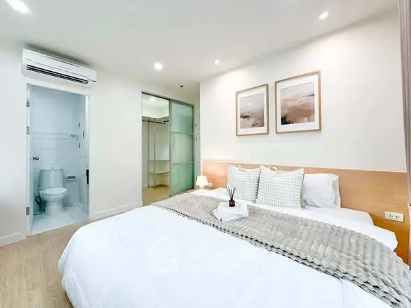 Modern bedroom with ensuite bathroom, featuring cozy decor and soft lighting for a relaxing ambiance.