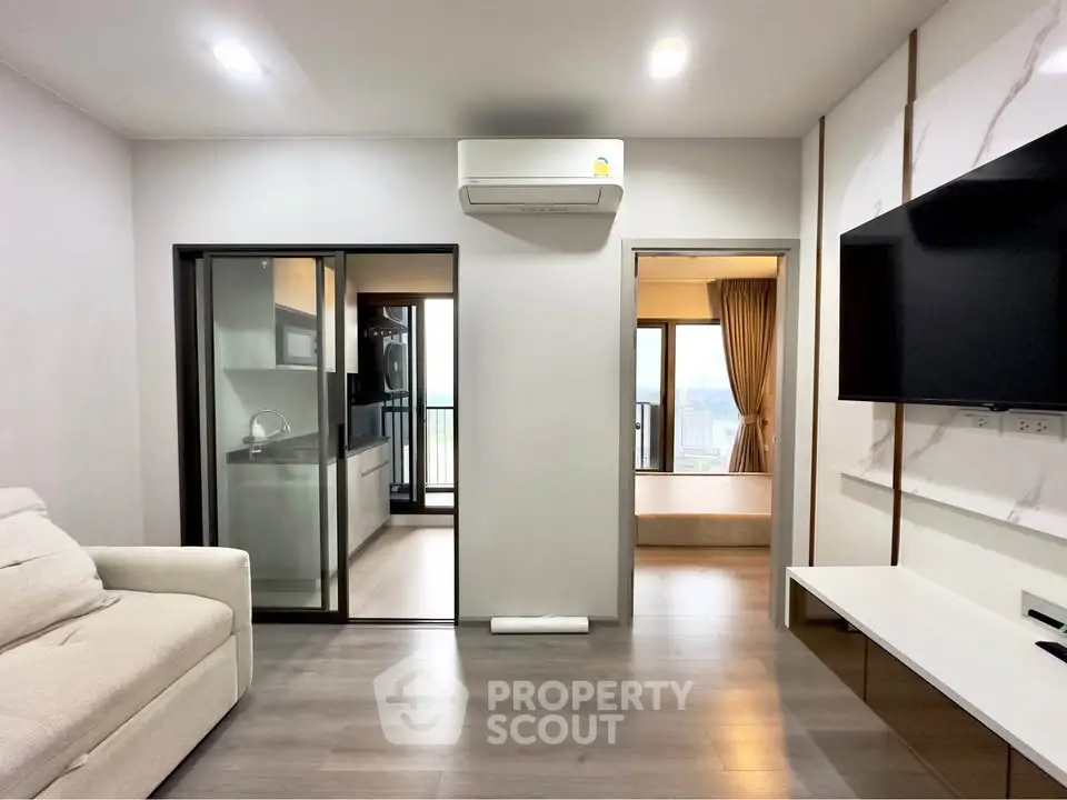 Modern living room with sleek design, open kitchen, and balcony view in a stylish apartment.