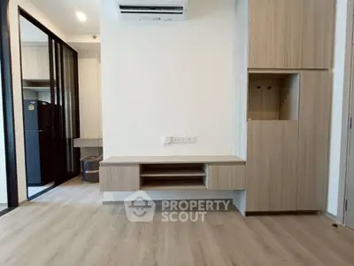 Modern apartment interior with sleek wooden cabinetry and air conditioning unit.