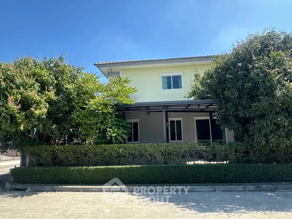 Charming two-story house with lush greenery and spacious driveway