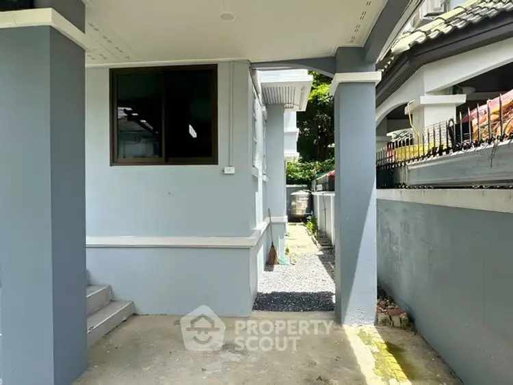 Charming exterior view of a modern home with a covered entrance and side pathway.