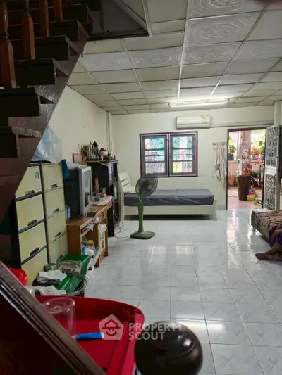 Spacious living area with tiled flooring and cozy furnishings in a residential home.
