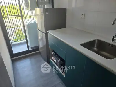 Modern compact kitchen with sleek cabinetry and balcony view