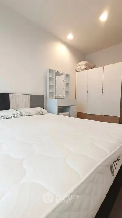 Spacious bedroom with modern furniture and comfortable mattress