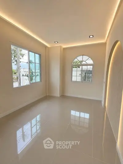 Spacious and bright living room with large windows and modern lighting