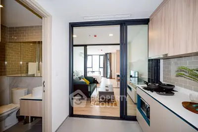 Modern apartment interior with open kitchen and living room, sleek design and natural light.