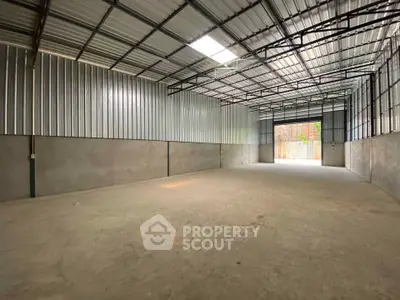 Spacious industrial warehouse with high ceilings and ample natural light.
