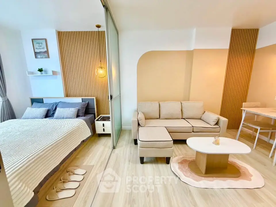 Modern studio apartment with cozy living area and stylish bedroom, featuring elegant decor and warm lighting.
