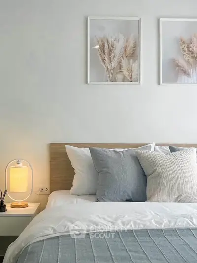 Modern bedroom with stylish decor and cozy bedding, featuring elegant wall art and ambient lighting.