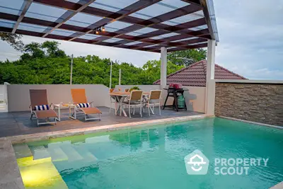 Luxurious outdoor pool area with covered patio and modern seating, perfect for relaxation and entertainment.