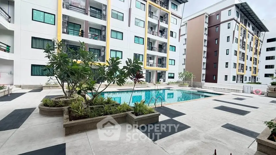 Modern apartment complex with pool and landscaped courtyard, ideal for urban living.