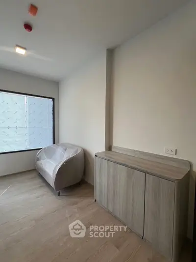 Modern minimalist room with wooden flooring and compact furniture, ideal for cozy living.