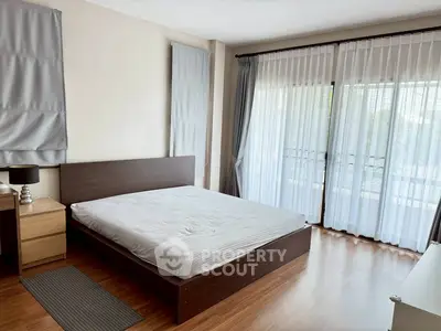 Spacious bedroom with large windows and modern furnishings
